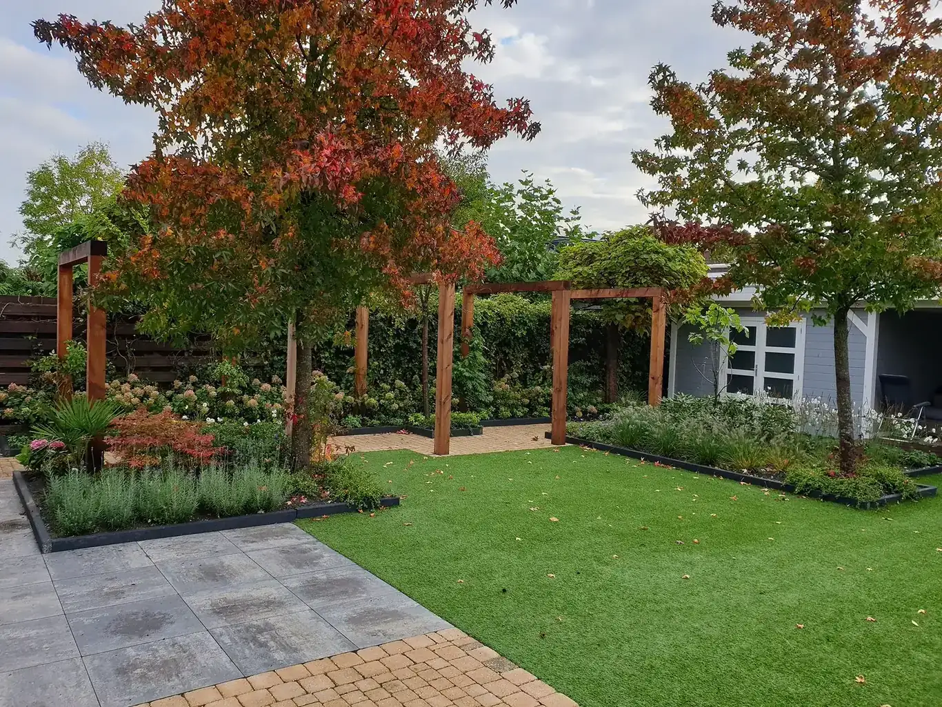 Door hovenier GS Gardens aangelegde tuin met pergola en najaarsbeplanting in Nieuw-Vennep